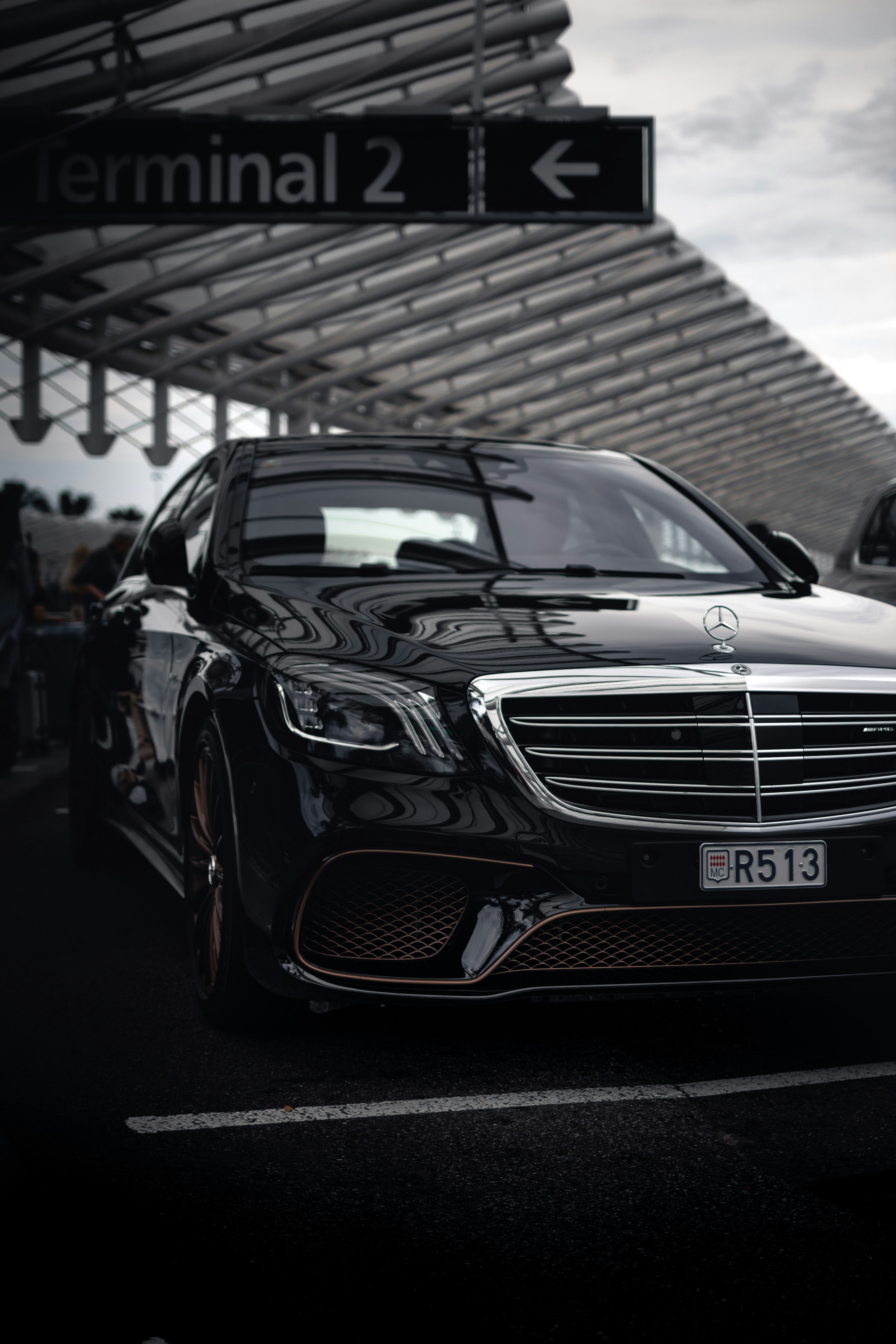Black sedan waiting beside an airport terminal