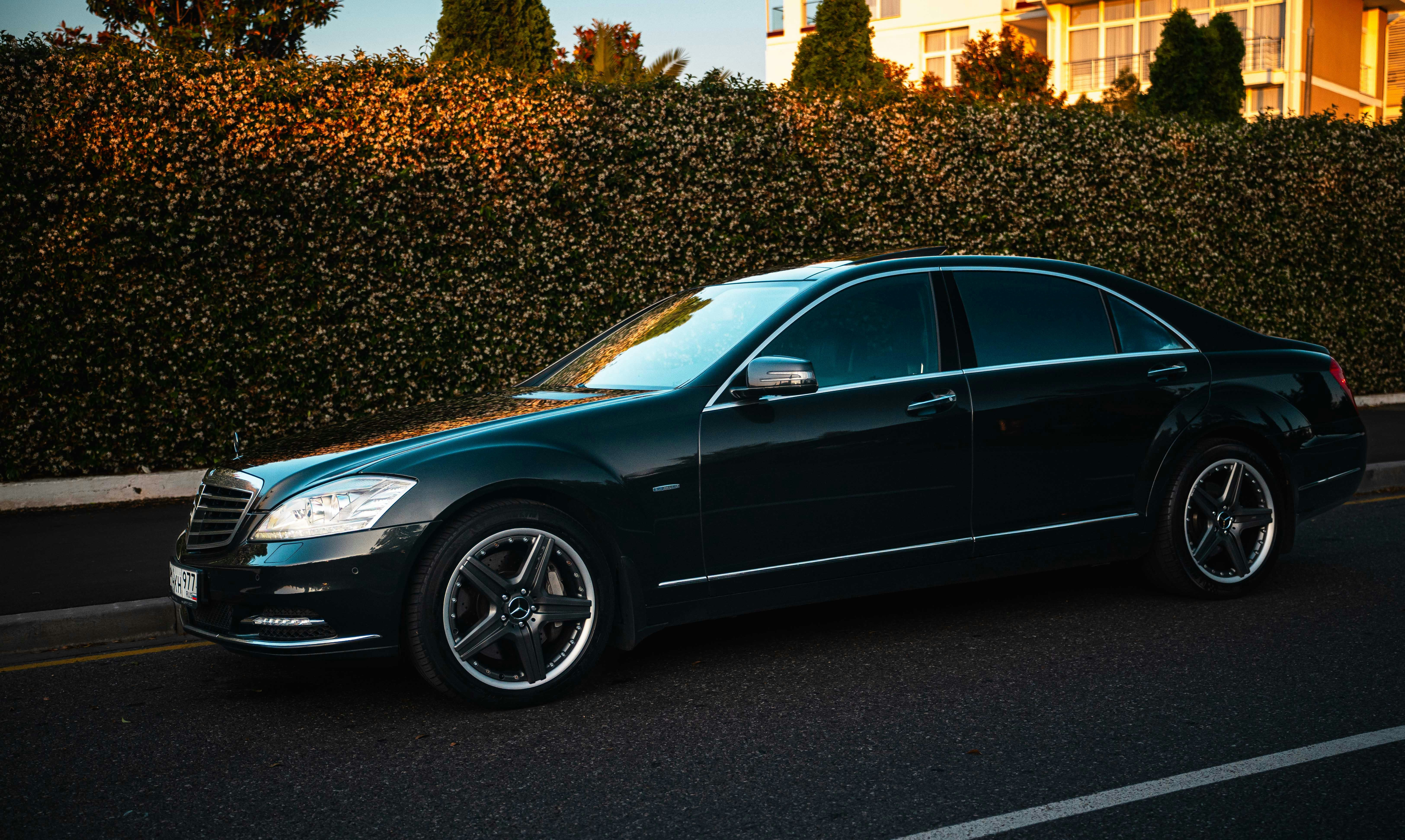 Black executive sedan parked beside a city street